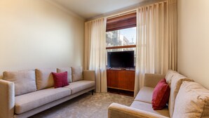 A living room with two sofas, a TV, and a wooden cabinet. - Central 4-Bedroom Apartment in Santa Catarina (Oporto)