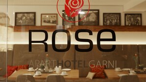 A restaurant with a modern interior, featuring a large logo of a rose and the word "ROSE" prominently displayed. - ApartHotel Rose Ellwangen (Ellwangen)
