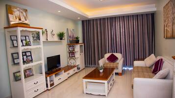 Departamento, 2 habitaciones | Sala de estar | Smart TV de 55 pulgadas con canales vía satélite y televisión