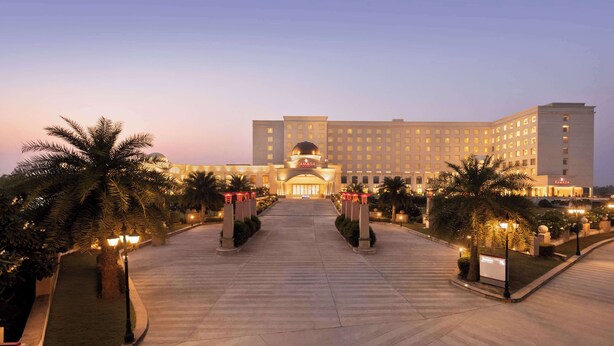 A large, well-lit hotel entrance with a central dome and multiple floors.