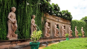 A garden with statues and a fountain.
