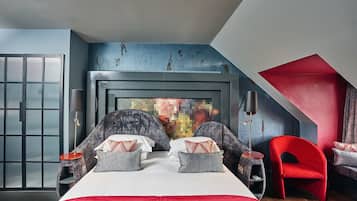 Une chambre moderne avec un grand lit, un fauteuil rouge et une vue sur la ville.
