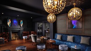 Un espace de détente moderne avec un canapé bleu, des poufs ronds et une cheminée.