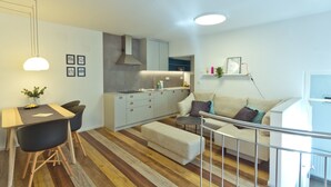 A modern apartment with a dining area, kitchenette, and living space. - City Centre Apartments (Ljubljana)