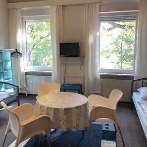 Classic Triple Room | Living area | 24-inch flat-screen TV with digital channels, TV - Bigus (Berlin)