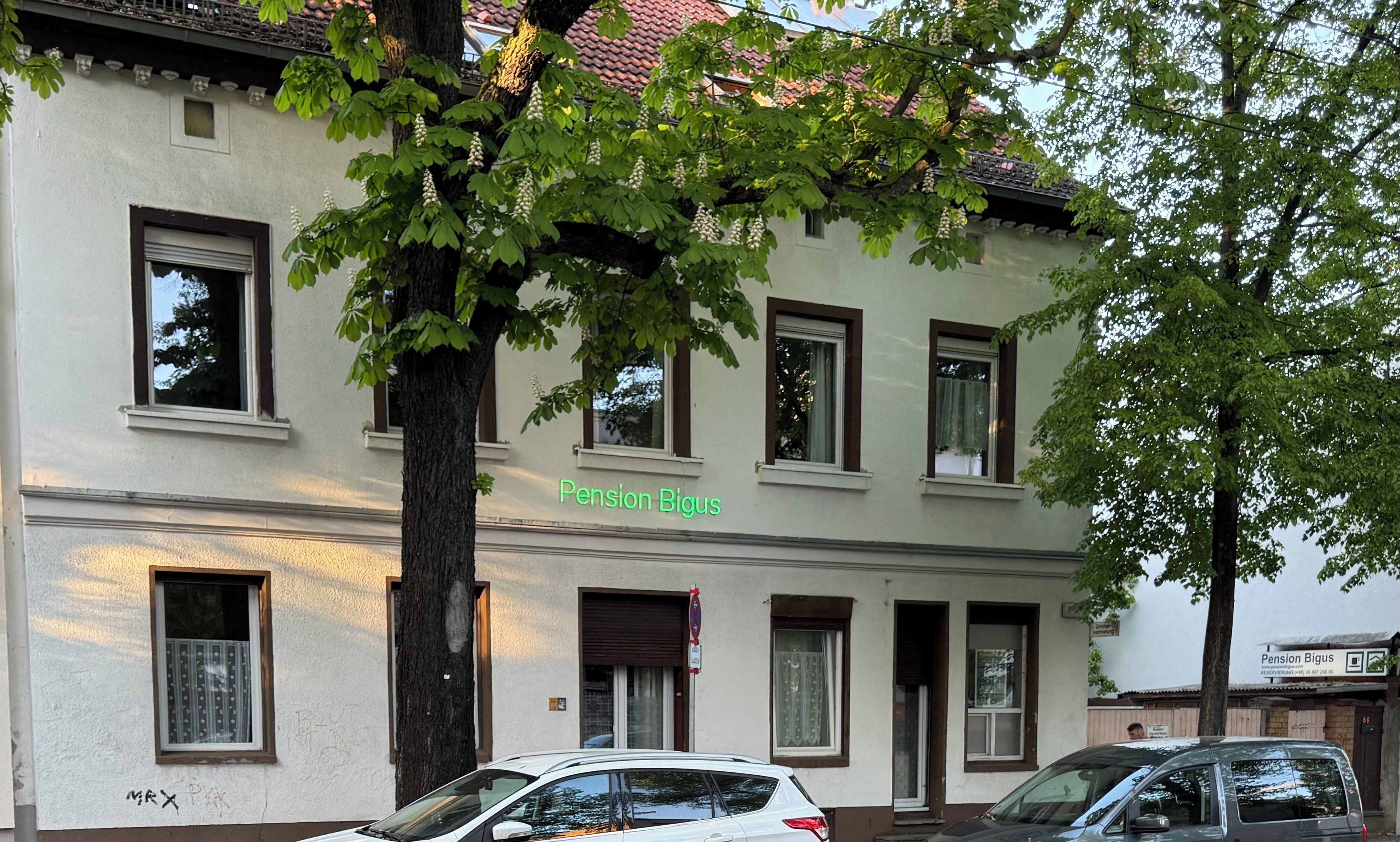 Ein Gebäude mit vielen Fenstern und einem Baum davor.