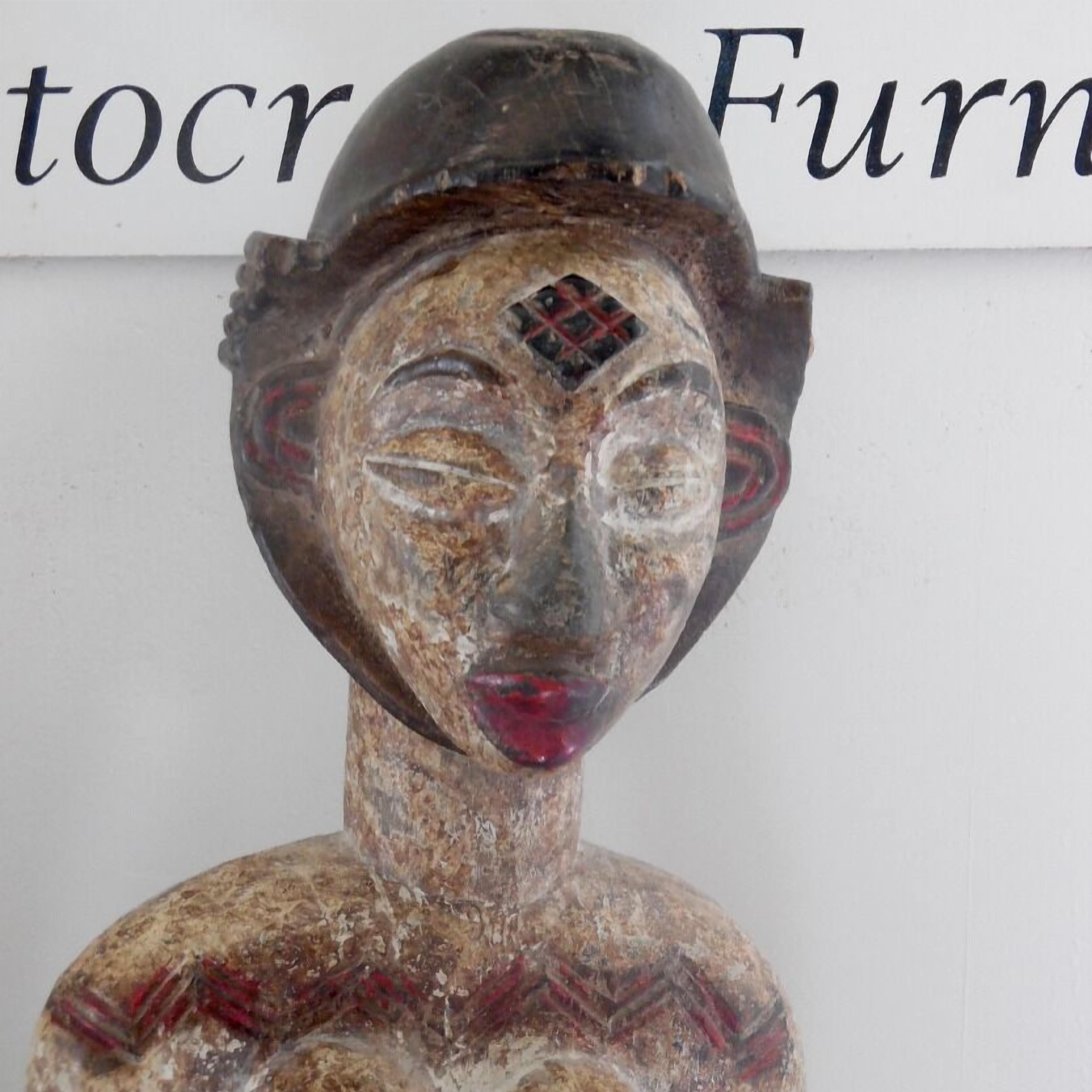 Une sculpture à la texture rugueuse, dont la tête est ornée d’un motif.