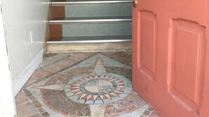 A staircase with metal handrails and a red door.