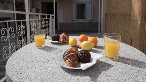 A table with pastries, oranges, and glasses of orange juice on a balcony. - Andrea&Leon Apartments (Mali Losinj)