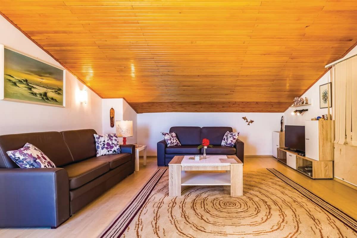 Een woonkamer met twee banken, een salontafel en een televisie.