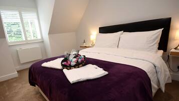 A bedroom with a bed, a window, a nightstand, and a lamp.