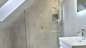 A modern bathroom with a glass-enclosed shower, a toilet, and a vanity with a mirror. - Apple Tree Place B&B (Tadley)
