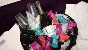A gift basket with champagne bottles, a bottle of Prosecco, and various chocolate bars. - Apple Tree Place B&B (Tadley)