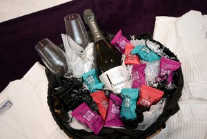 Cesta de presentes com garrafas de champanhe, uma garrafa de Prosecco e diversas barras de chocolate.