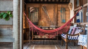 Una habitación rústica de madera con una hamaca, muebles de madera y decoración tradicional.