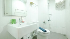 Ein Badezimmer mit Waschbecken, Toilette, Spiegel und Dusche.