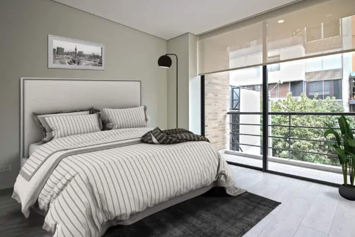 Ein modernes Schlafzimmer mit einem großen Bett, einem Stadtbild an der Wand und Blick auf ein Gebäude durch das Fenster.