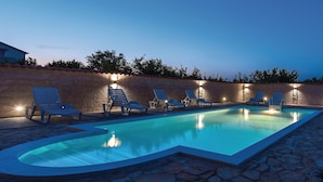 A swimming pool with lounge chairs and stone flooring. - Amazing home in Cista Velika (Cista Velika)
