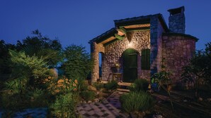 A stone building with a green door and a checkered pathway leading to it. - Amazing home in Cista Velika (Cista Velika)