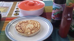 Un plato de desayuno con huevos, patatas ralladas y frijoles.