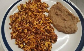 A plate with scrambled eggs and a piece of flatbread. - Hotel Posada del Yaqui (Cajeme)