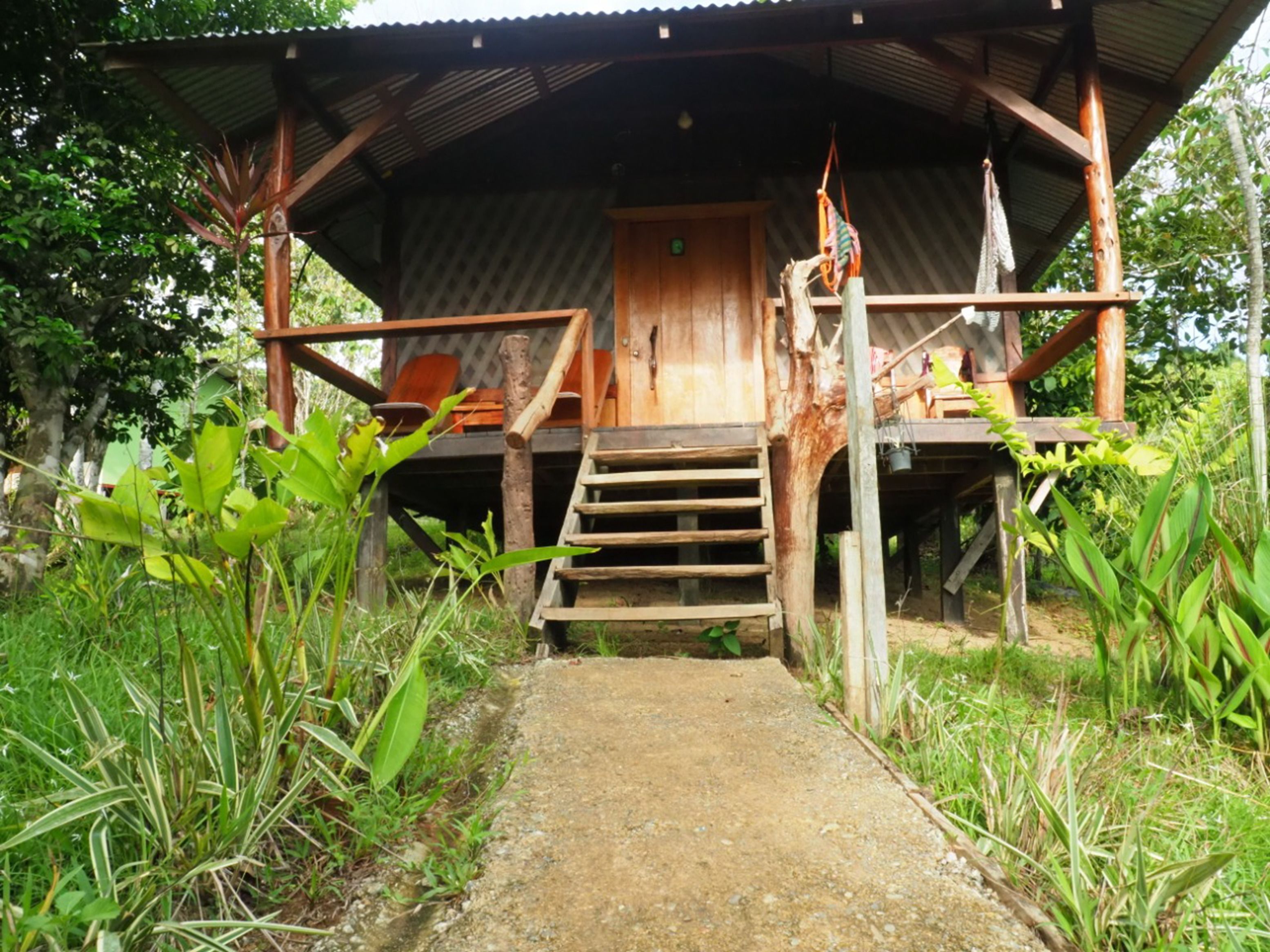 A rustic wooden structure with a wooden staircase leading to a door.