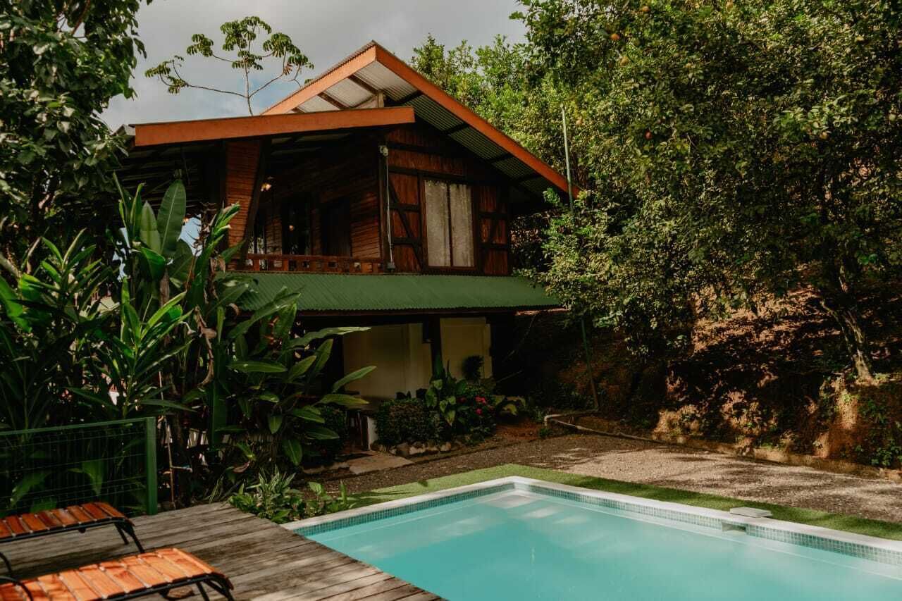 Een huis met twee verdiepingen en een zwembad in de achtertuin.