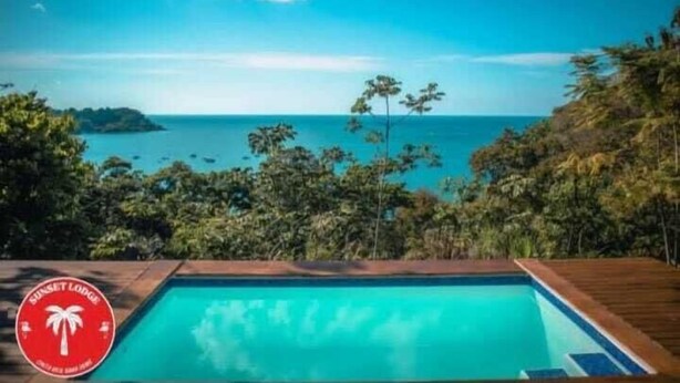 Una piscina amb vistes a l'oceà i un paisatge tropical.