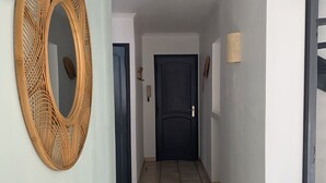 A hallway with a wooden mirror, a dark door, and a light wall.