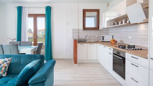 A modern kitchen with white cabinets, a built-in oven, and a microwave. - Kaylie Apartment, 3 bedroom place in Pula, Croatia (Pula)