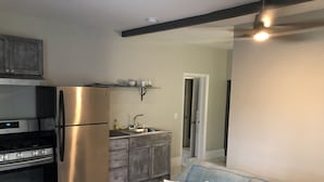 A modern kitchen with stainless steel appliances, a built-in oven, and a grey countertop. - Beach Hideaway (Nassau)