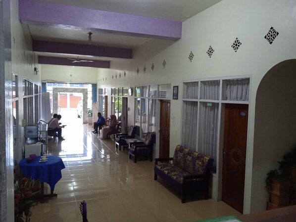 A spacious lobby with a reception desk, seating area, and a sofa. - Trivadoh Syariah Hotel (Padang Panjang)