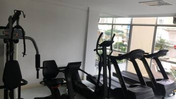 Una palestra con attrezzature per allenamento, tra cui tapis roulant, ellittiche e macchinari per pesi.