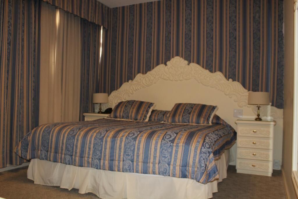 Un dormitorio con una cama grande, dos mesitas de noche y una mesilla.