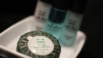 A close-up of a hotel room's minibar with a bottle of minibar coffee and a bottle of minibar water.