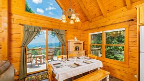 Une cabane en bois avec une table à manger dressée pour quatre personnes, un banc et une vue sur l’extérieur.