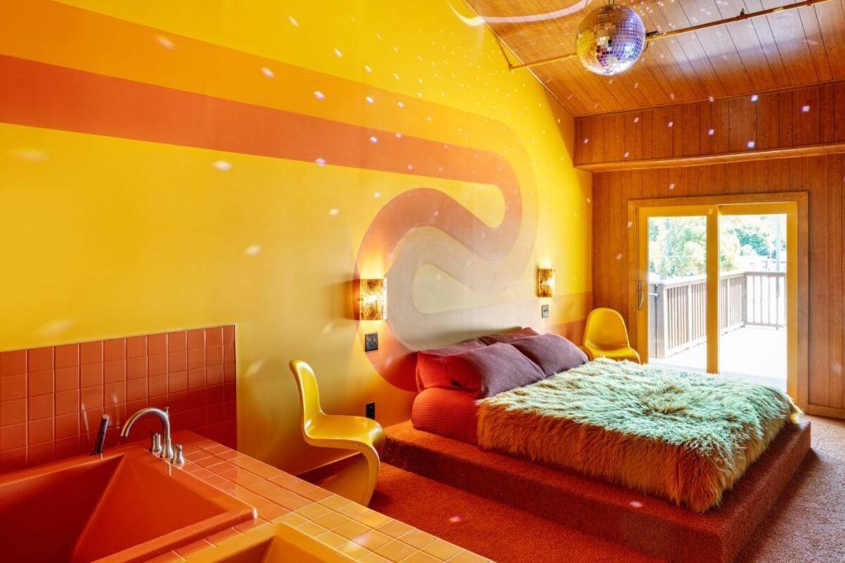 Un dormitorio moderno con una cama grande, techo de madera y vistas al exterior.