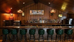 A bar area with a checkered floor, wooden walls, and green bar stools. - The Dive Motel & Swim Club (Nashville)