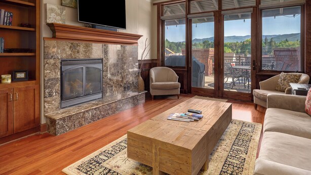 Ein Wohnzimmer mit Kamin, Couchtisch aus Holz und gemütlicher Sitzgelegenheit.
