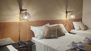 A hotel room with two beds, a wooden headboard, a minibar, and wall-mounted lamps. - Pousada Casa Bella (Itaberaba)