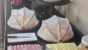 A kitchen counter with cooking utensils, a loaf of bread, and food items. - Pousada Casa Bella (Itaberaba)