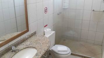 A small bathroom with a sink, toilet, and shower.