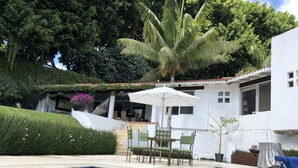 A swimming pool with a white house in the background, surrounded by greenery and a hammock. - Stunnishing House in Cuernavaca with 20 people accommodation. (Los Limoneros)