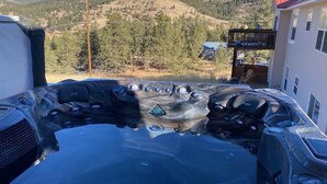 A hot tub with multiple jets, surrounded by a mountainous landscape.