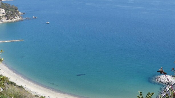 A coastal view with a beach, clear blue water, and a rocky outcrop. - 2 bedroom nice apartment in Albenga (Albenga)