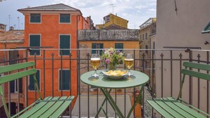 A balcony with a table set for two, two glasses of beer, a plate of food, and a vase of flowers. - 2 bedroom nice apartment in Albenga (Albenga)