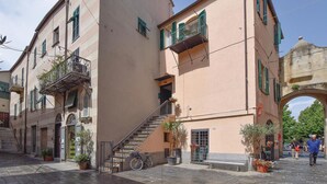 A narrow street with buildings featuring balconies and a staircase leading to an entrance. - 2 bedroom nice apartment in Albenga (Albenga)