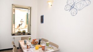 A dining area with a table set for breakfast, including pastries and fruit. - 2 bedroom nice apartment in Albenga (Albenga)