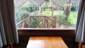 A wooden deck with a view of a garden. - Cabañas Manamar (Villa Gesell)