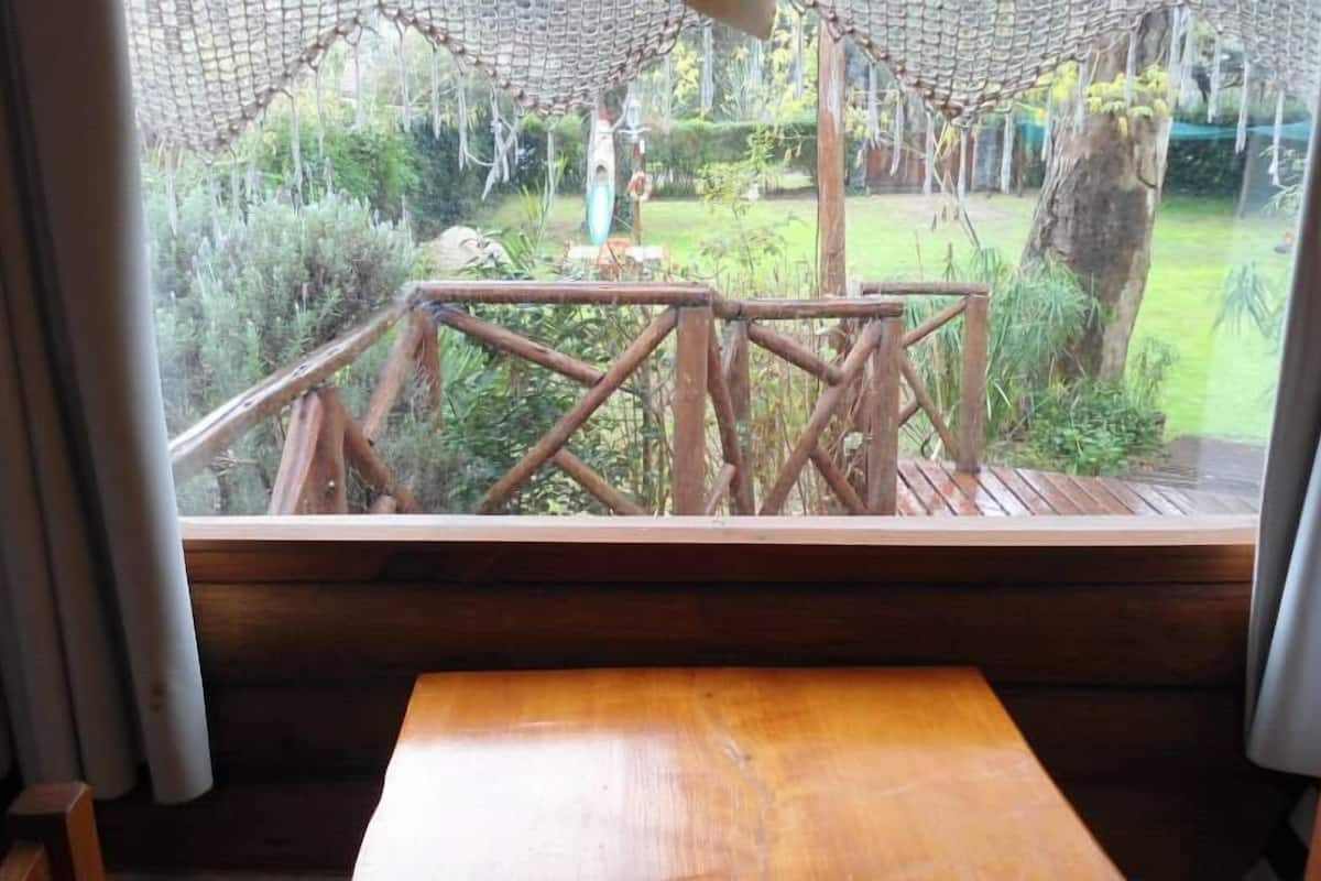 Una terraza de madera con vistas a un jardín.
